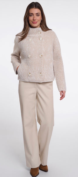A woman modelling Rino & Pelle light beige textured cropped jacket with a high mock neck and double-breasted buttons, paired with matching beige wide-leg trousers, against a plain white studio background.