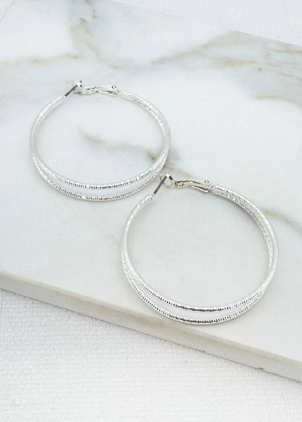 Envy gold  hoop earrings on a marble surface