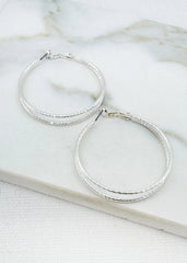 Envy gold  hoop earrings on a marble surface