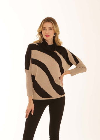 A woman modeling a beige and black wavy striped knit turtleneck sweater with long sleeves, paired with black pants, against a plain white studio background.