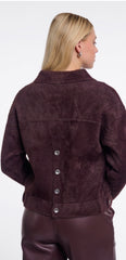 A woman shown from the back wearing a dark plum-brown Rino Pelle textured jacket with a button closure down the back, paired with matching dark pants, against a plain white background.