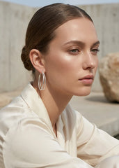 Woman wearing Envy gold  hoop earrings with a neutral background