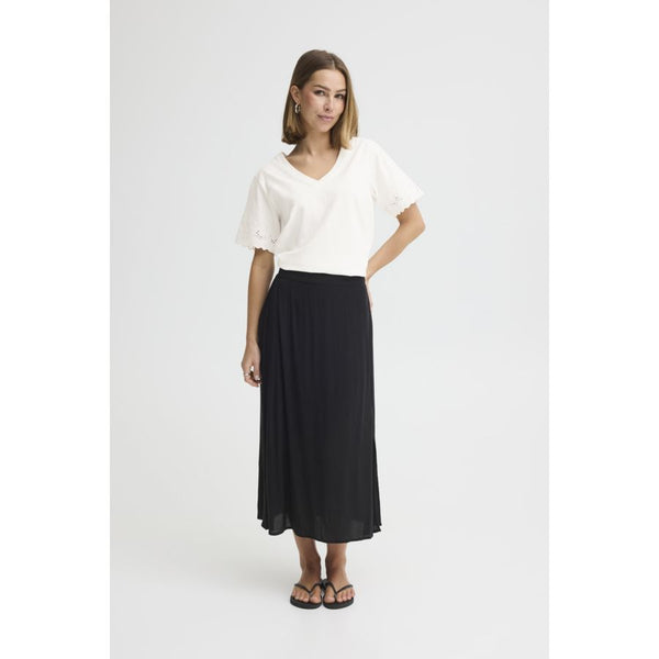 Woman wearing a white top and black skirt on a white background