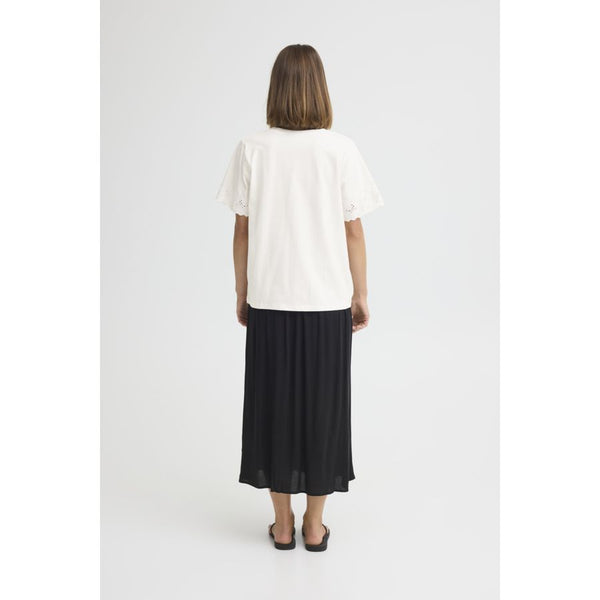 Person wearing a white top and black skirt on a white background