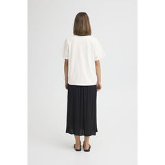 Person wearing a white top and black skirt on a white background