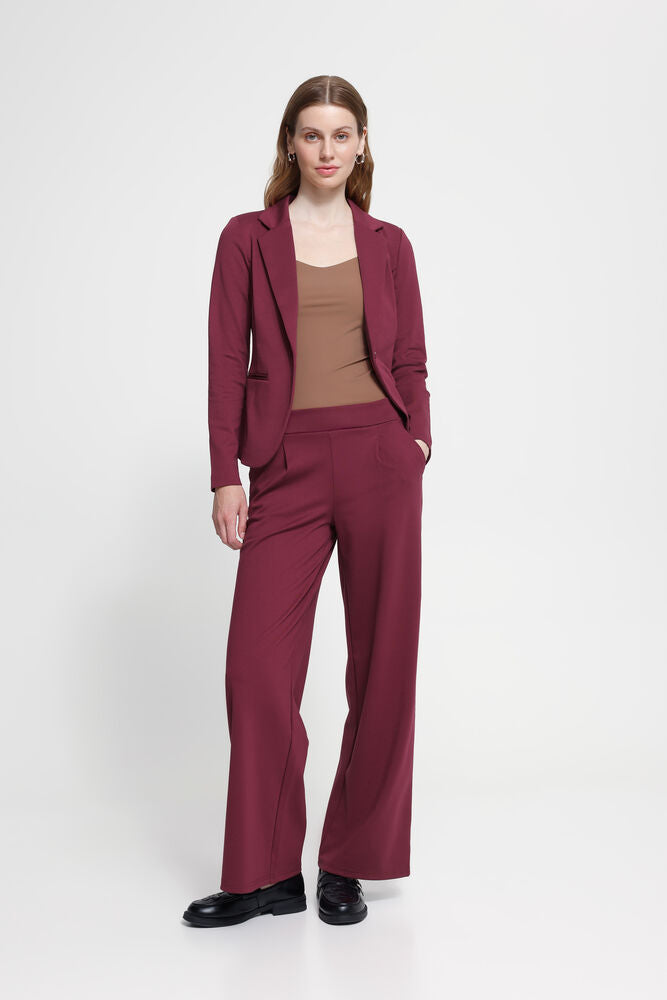 Woman wearing Ichi burgundy wide leg trousers with matching Jacket against a white background