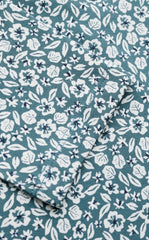 A close up of a fabric  with an allover floral print in white and blue. 