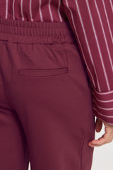 Maroon pants with a striped shirt on a white background