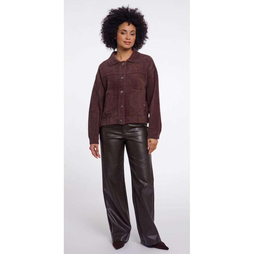 A model wearing a Rino & Pellet dark brown textured button up jacket and dark brown wide-leg faux-leather pants, standing against a light grey studio background.