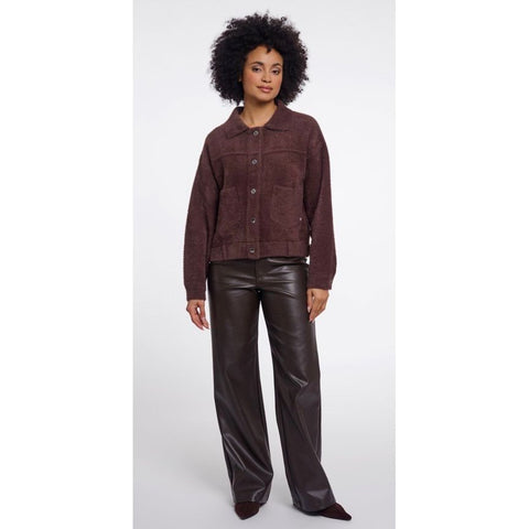 A close up of a dark brown, fuzzy textured fabric with a small stitched pocket detail.