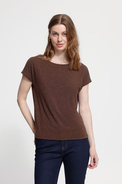 Woman wearing a brown t-shirt and blue jeans on a white background
