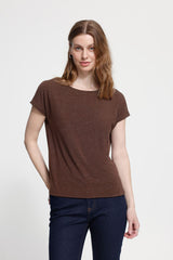 Woman wearing a brown t-shirt and blue jeans on a white background