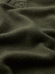 Close-up of a dark olive green knit fabric with soft folds and a ribbed texture.