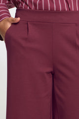 Close-up of maroon pants with a neutral background