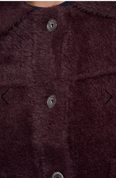 Close up of a dark plum faux fur Rino Pelle jacket with three dark metal buttons on a white background.