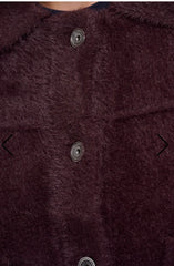 Close up of a dark plum faux fur Rino Pelle jacket with three dark metal buttons on a white background.