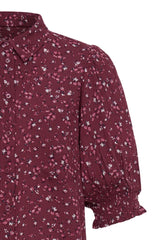 Close up of floral print Ichi shirt with short sleeves on a white background.