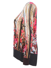 A long-sleeve sheer top with a vibrant abstract floral and brushstroke print in pink, red, gold, and black, featuring solid black cuffs and hem.