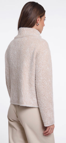 A woman shown from the back wearing a Rino & Pelle cropped knit jack in a light oatmeal beige colour, paired with matching beige trousers, against a plain white studio background.