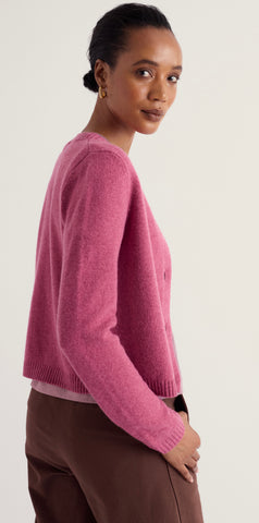 Close up Seasalt pink knit fabric with three visible brown buttons on a soft, textured surface.