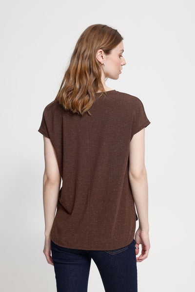 Woman wearing a brown t-shirt and blue jeans on a white background