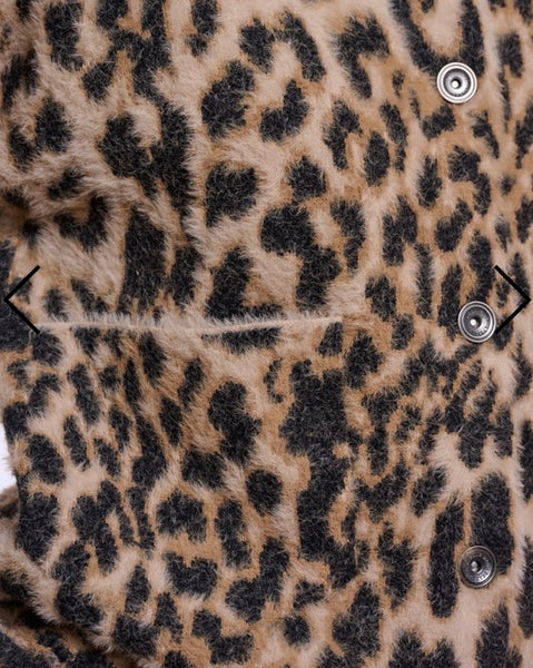Close-up of a leopard print Rino Pelle faux fur garment with black buttons and a horizontal seam.