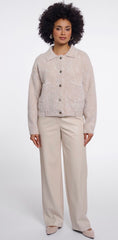 A woman modelling Rino & Pelle  light beige textured button-up cardigan with a collar and front pockets, paired with beige wide-leg trousers, against a plain white studio background.