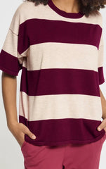 A person wearing Ichi striped Top with wide horizontal stripes.  A crew neck,  short sleeves with hands in pockets of pink pants. 