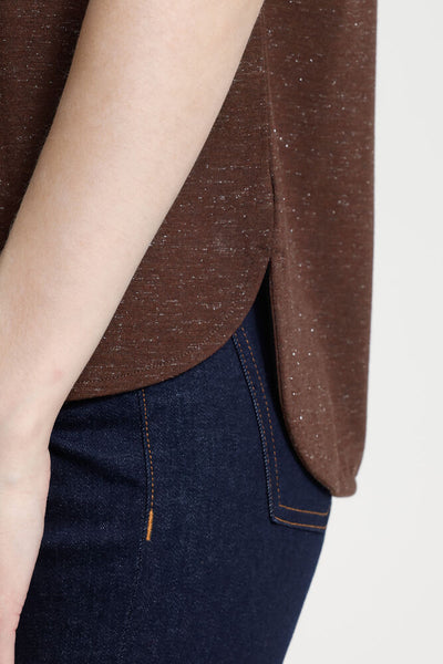 Brown top and dark blue jeans on a plain background