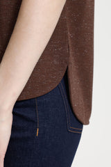 Brown top and dark blue jeans on a plain background