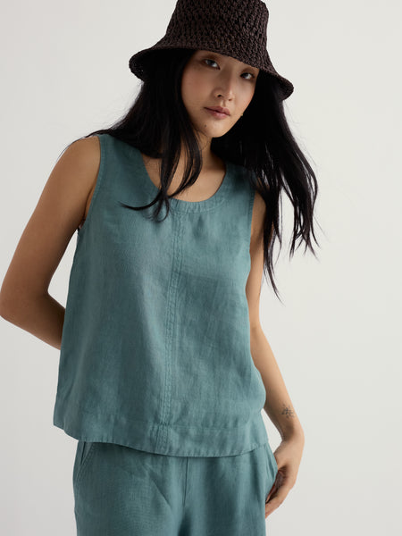 Wearing a bucket hat and a sleeveless top.