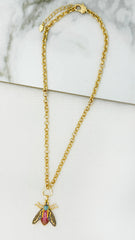 Envy Gold necklace with a bee pendant on a marble surface