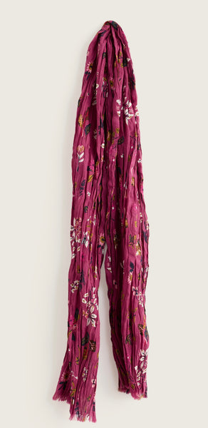 Seasalt long, pleated scarf in a dusty magenta-purple colour, decorated with a small-scale floral pattern in white, green, and yellow, shown against a plain light grey background.