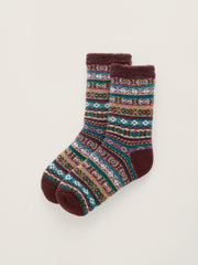 A pair of plush Seasalt cabin socks with a multicolor Fair Isle pattern and, heels, and toes, displayed on a light beige background.