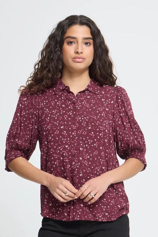 Ichi burgundy short-sleeve blouse with a white and light pink floral print, featuring puffed sleeves and a collar, shown against a plain white background.