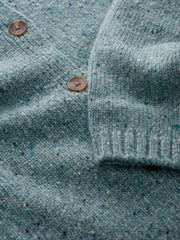 Close-up of a textured teal fabric cardigan with buttons