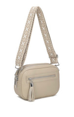 Beige crossbody bag with a patterned strap on a white background