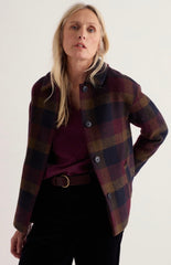 A woman wearing Seasalt checked pattern button-front jacket over a burgundy top and black pants, photographed against a plain light background.