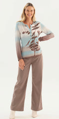 A woman modelling a two-piece lounge set featuring Dolcezza long-sleeve button-up top with a blue, beige, and brown gradient and branch print, paired with matching wide-leg pants, against a plain white studio background.