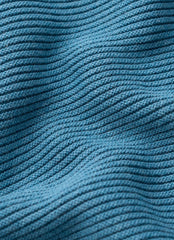 Close up of a blue ribbed knit fabric texture with horizontal rows and soft folds.
