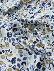 Floral patterned fabric with blue, green, and brown colours on a white background.