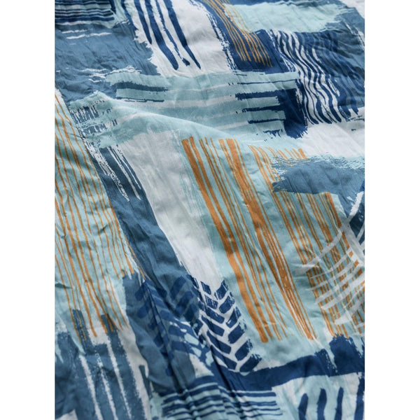 Close-up of fabric with blue and orange abstract pattern.