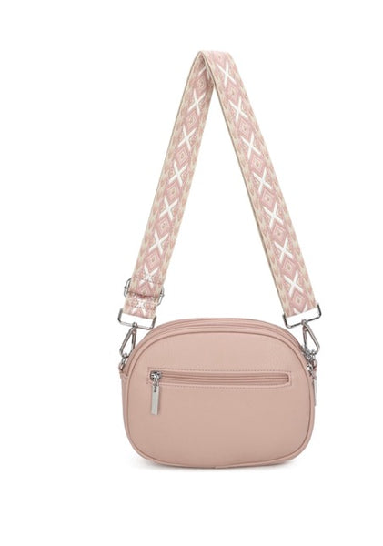 Women’s Pink crossbody bag with a patterned strap on a white background