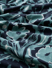 Close-up of floral patterned fabric with dark and light green colours.