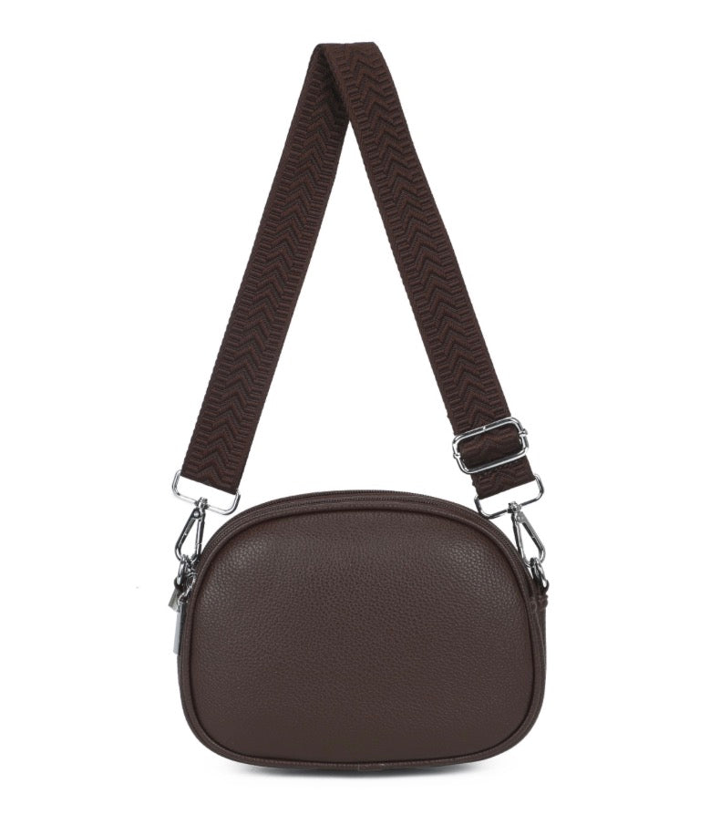 A crossbody coffee handbag with adjustable pattern strap. With zipper fastening displayed on a white background.