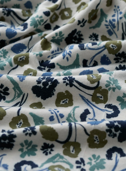 Close-up of floral patterned fabric with blue, green, and black colours on a white background.