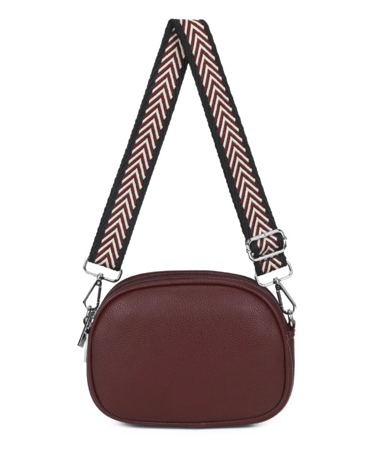 Crossbody bag small in wine with pattern strap and adjustable and detachable strap. With zipper closure display on a white background.