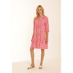 Model wearing Pomodoro short pink floral print dress with white sandals 