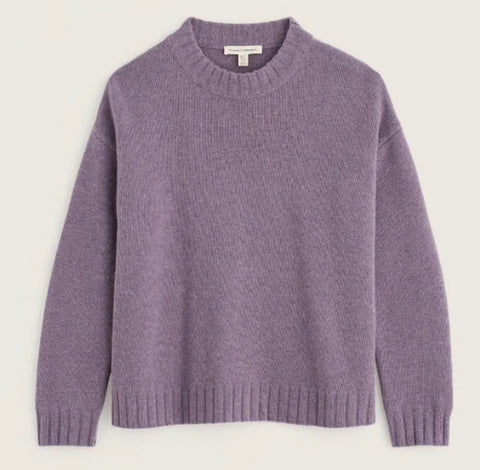 Close-up of a ribbed knit sweater in a muted dusty lavender-purple color, showing the collar and a small white neck label that reads 'SEASALT CORNWALL'.