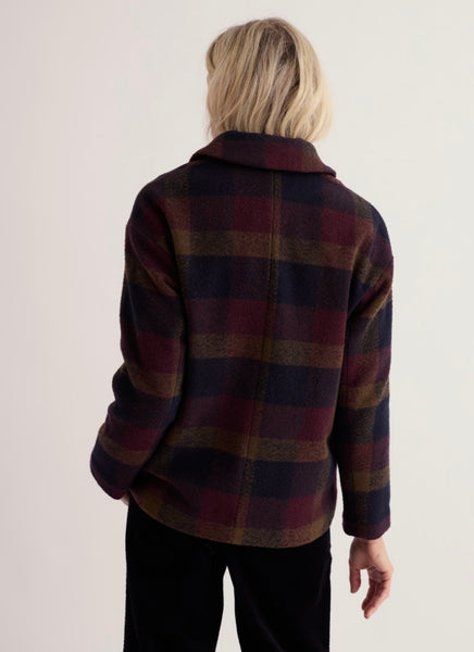 Back profile of woman modelling a check pattern wool Jacket on a white studio background.